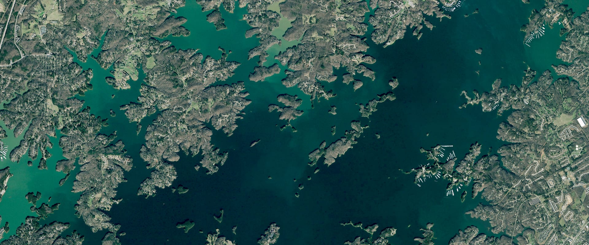 Aerial photo of the south end of Lake Lanier near Buford Dam: branching wooded coves around deep green open water